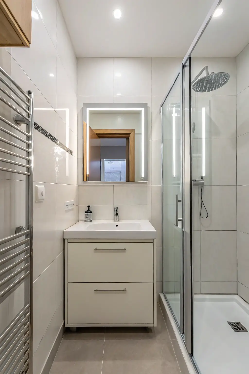 small modern bathroom with a tall, narrow frameless mirror that creates the illusion of more space.